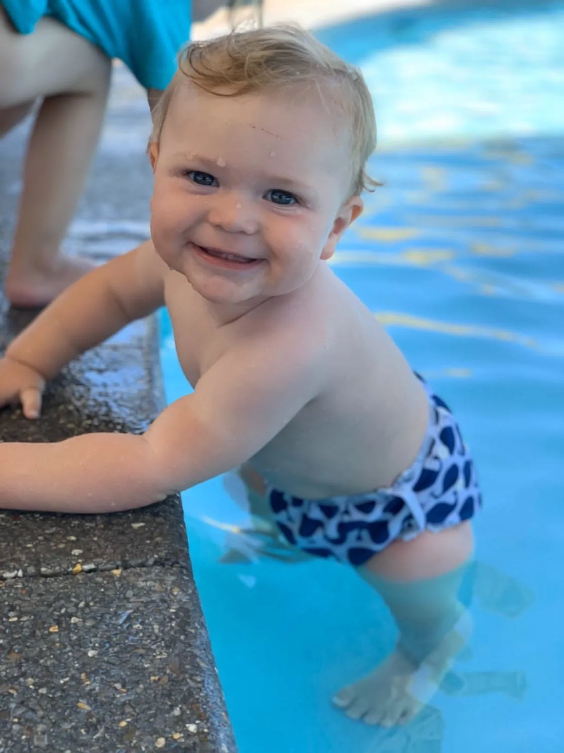 Baby wearing a reusable swim nappy near the water