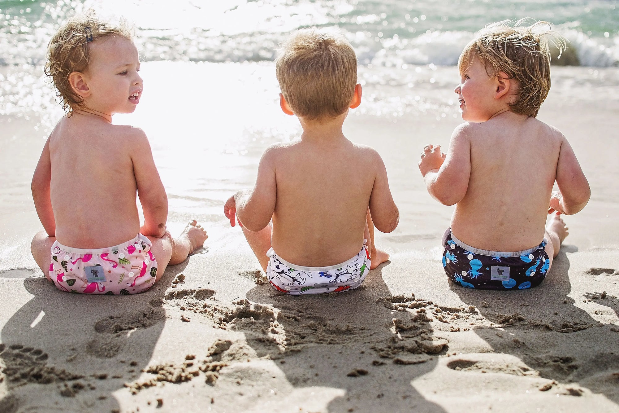 Children on the beach wearing reusable swim nappies